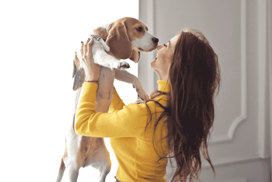 Mulher segurando uma cadela Beagle em um gesto de carinho, representando nomes populares para fêmeas de cachorro em 2025.