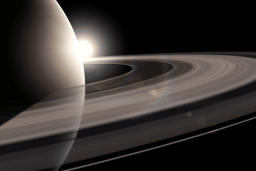 Saturno visto de perto com seus anéis amplos e brilhantes iluminados pela luz solar, destacando a estrutura fina do sistema de anéis.