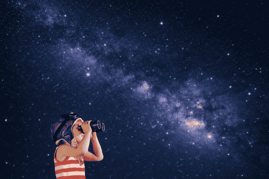 Pessoa observando o céu estrelado com binóculo sob a Via Láctea, em cena de introdução à astronomia amadora.