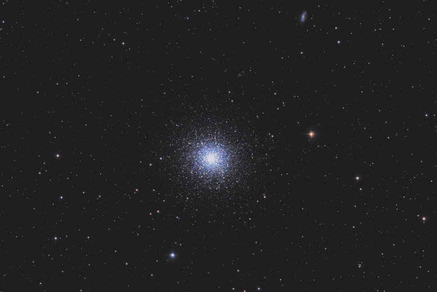 Aglomerado estelar globular brilhante no centro da imagem, cercado por estrelas espalhadas em fundo escuro do espaço.