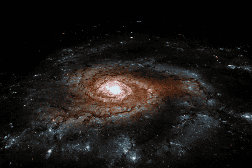 Galáxia espiral vista de frente, com núcleo brilhante e braços cheios de poeira e regiões estelares sobre fundo escuro do espaço.