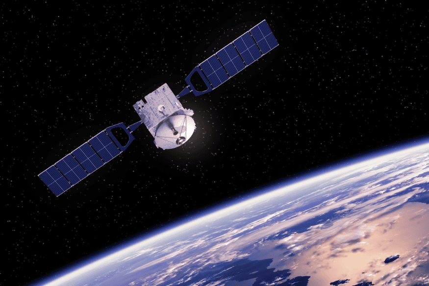 Satélite artificial em órbita sobre a Terra, com painéis solares abertos e o planeta visível ao fundo no espaço.
