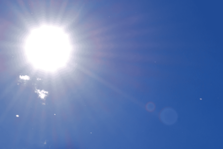 Sol muito brilhante em céu azul durante o dia, imagem que ilustra a aparência da nossa estrela vista da Terra e a discussão sobre sua cor real.