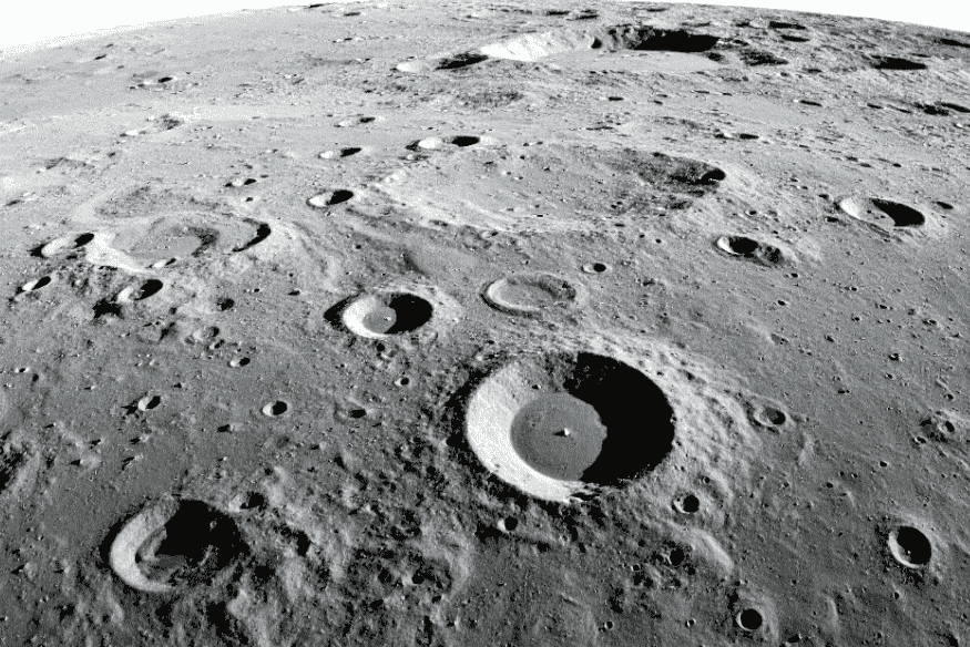 Paisagem da Lua repleta de crateras circulares em diferentes tamanhos, vista em tom acinzentado sobre terreno árido e sem atmosfera.