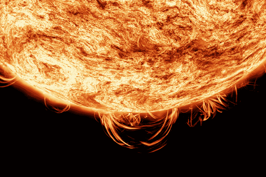 Detalhe da superfície do Sol com filamentos de plasma e intensa atividade magnética na borda, relacionada a explosões solares.