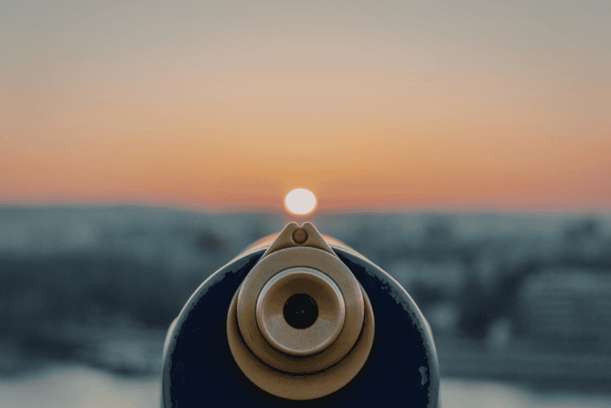 Vista frontal de telescópio alinhado com o Sol ao horizonte, destacando a importância do ajuste fino para obter imagens mais nítidas.