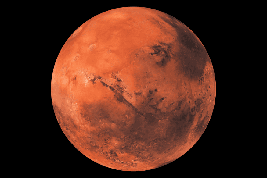 Marte visto de frente com superfície avermelhada, crateras e grandes formações geológicas visíveis sobre fundo escuro.