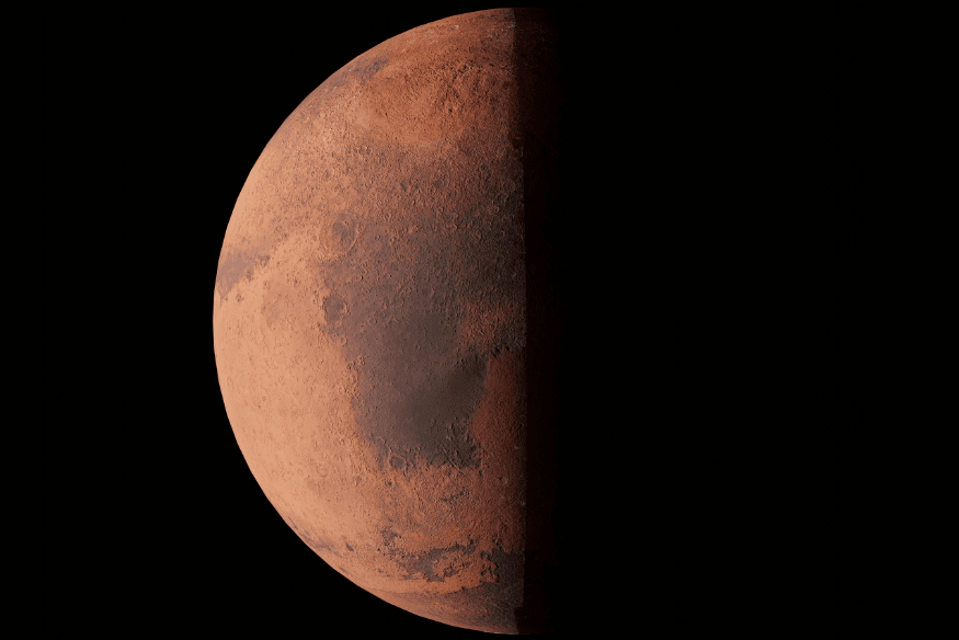 Marte em meia fase visto no espaço, com parte iluminada e parte escura, destacando o planeta vermelho em fundo preto.