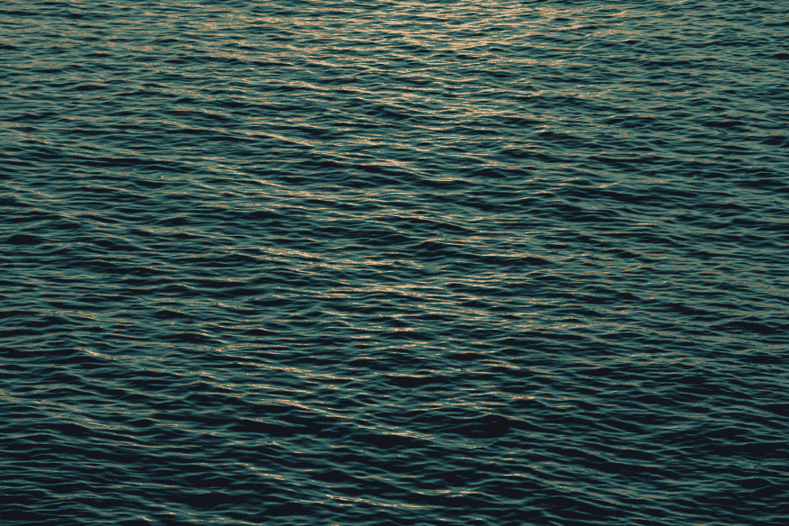 Superfície de água com pequenas ondulações, imagem conceitual sobre oceanos extensos em exoplanetas cobertos por água.