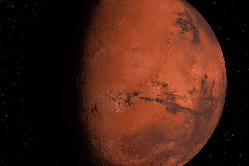 Close de Marte mostrando sua superfície vermelha com crateras e grandes formações geológicas em destaque.