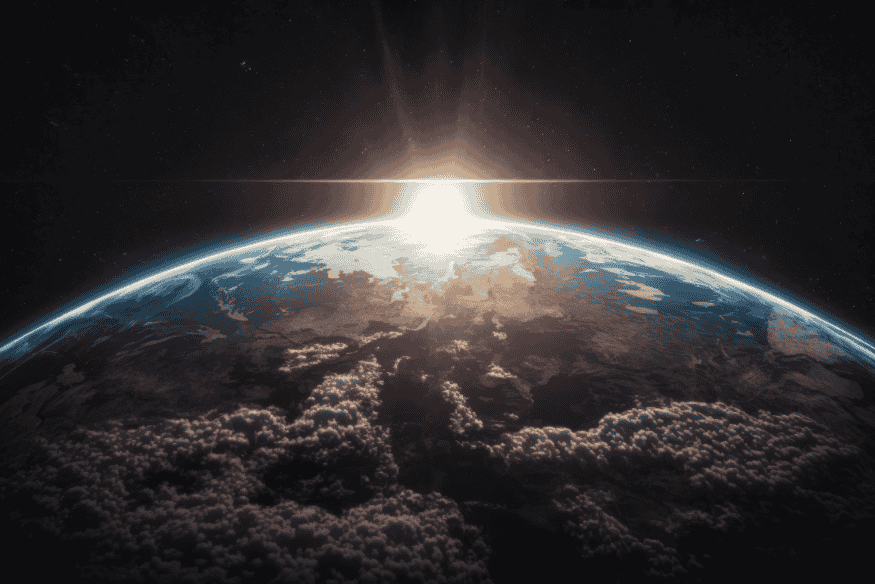 Curvatura da Terra vista do espaço com a luz do Sol surgindo no horizonte, imagem que representa a influência do Sol no Sistema Solar.