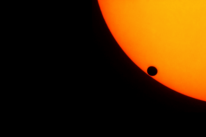 Pequeno planeta em trânsito na borda de uma estrela brilhante, destacando o momento em que o astro começa a cruzar o disco estelar.